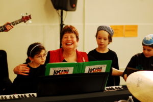 Music Director Helene Reisler works with two students during a rehearsal.