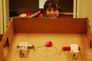A student shows off his hockey-style arcade game, still in progress.