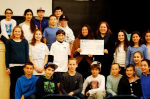 Sixth graders pose with the large check they donated to the Jewish Federation after the Shuk for Shalom.