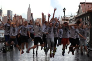 Students jump in front of the New York skyline.