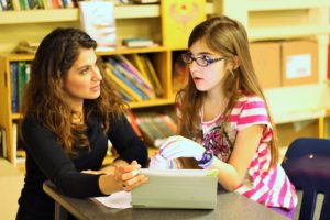 A sixth grade student explains her idea to General Studies teacher Lisa Schopf.