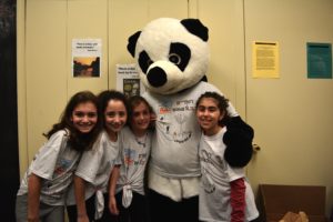 Students pose for a photo with the school mascot, a panda, at the Dance-a-Thon.