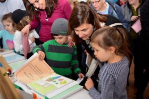 Students show their work to parents and guests at the First Grade Bayit Patuach (Open House).