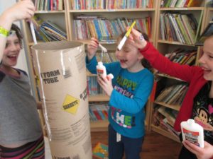 Students paint a column to represent a tree trunk for their Bayit Patuach (Open House).