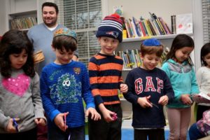 Kindergarten students hold hands as they cut the ribbon on the new South Campus Community Library.