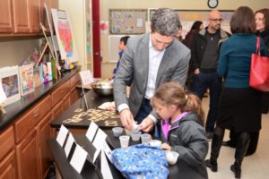 A student leads a parent through one of the Science activities.