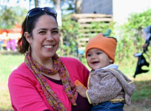 Incoming Elementary School Director Arielle Derby smiles for the camera with her infant son.