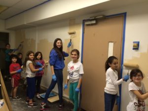 Students paint the walls of the Homeless Chidren's Playtime Project.