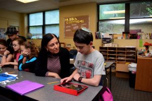 Hebrew teacher and Instructional Leader Shoshana Sfarzada works with students on their family immigration documentary films.