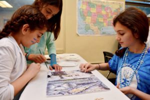 Three students work to recreate a piece of a famous mosaic.