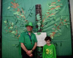 A student and a staff member pose in front of the completed tree.