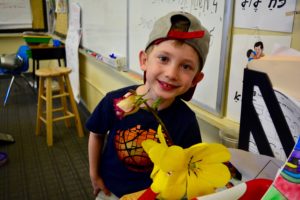 A student smells a flower during "Bring a Plant to School Day"