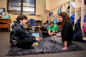 Lisa Schopf sits one-on-one with a sixth grade student.