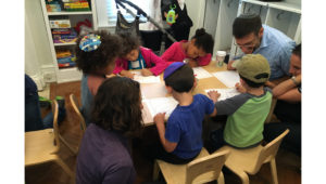 Children and their parents work on a STEM activity together.