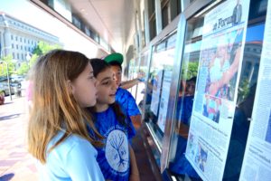 Sixth graders read headlines on the display outside of the Newseum.