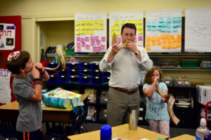 A JPDS-NC parent and his two children all blow shofar together for a class.