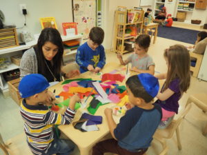 Pre-Kindergarten students work with Hebrew teacher Shani Daniel on a Rosh Hashanah art project.