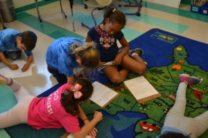 Second graders work together with their peers on the floor at the Horace Mann School.