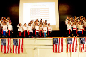 First graders sing and dance to "You're a Grand Old Flag" at the annual JPDS-NC Veterans Day Performance.