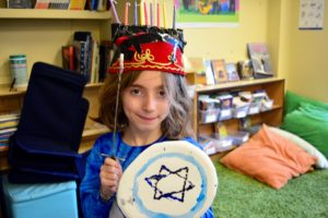 A student shows off her "Chanukah Spirit" gear, including a Maccabean shield!