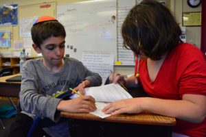 Fourth Grade students work together on their class project about political asylum seekers.