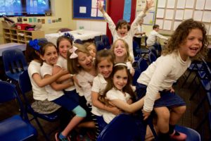 First graders celebrate ebulliently after receiving their siddurim (prayerbooks).