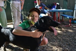 A student poses with his dog, a black lab, after giving his presentation.