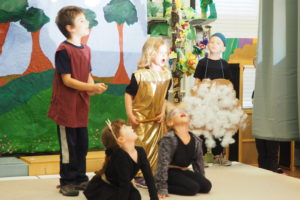 Students playing animals howl at the sky as they perform their class play.