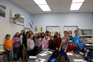 The sixth grade class poses for the camera with Dr. Erica Brown.