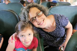 Third grade teacher Jessica Friedman smiles with a student on the school bus.