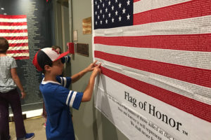 A fifth grade student reads names from a Flag of Honor at the National Museum of American Jewish Military History.