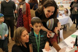 Students show off their work to a parent at their Museum of the Universal Languages of Childhood.