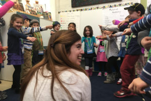 Kindergarten Hebrew teacher Jennie Berger plays a game with a circle of students.