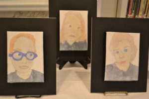 Three of the children's "Sad" self-portraits, showing muted colors and serious expressions.