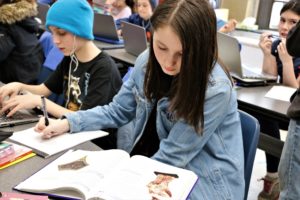 A sixth grade student reads a textbook about ancient Greece.