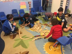 Sixth graders play trains with Kindergartners at CentroNia.