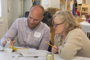 First grade teacher Tami Weeks works on a project with a participant at the Community Day of Learning.