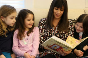 Hebrew Teacher Vered Goldstein reads a story with first grade girls.