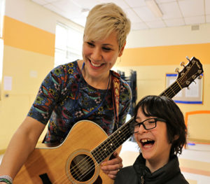 Art teacher Jill Stepak leads a lively tefilah with her guitar.