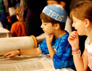 A student reads from a Torah scroll at Chagigat HaChumash, the Celebration of the Five Books of Moses, an annual tradition for third grade students.