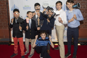 A group of sixth grade students pose together on the red carpet at the premiere of their student-made school documentary.