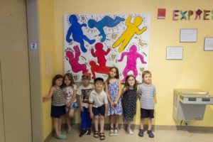 Pre-kindergartners pose in front of one section of the mural.