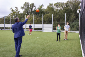 Councilmember Brandon Todd plays catch with visiting alumni on MILTON’s rooftop playfield during a tour of the new campus.