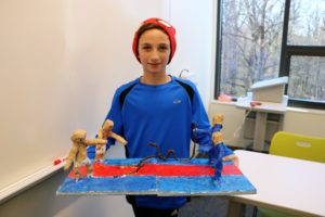 A student displays his finished artwork, capturing the movement and energy of the Biblical story of Aaron's rod becoming a serpent and swallowing the rods of Pharaoh's magicians.